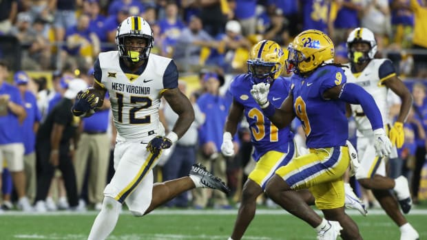 Sep 1, 2022; Pittsburgh, Pennsylvania, USA; West Virginia Mountaineers tight end CJ Donaldson (12) runs after a catch as defensive back Erick Hallett (31) and defensive back Brandon Hill (9) chase during the fourth quarter at Acrisure Stadium. Pittsburgh won 38-31. Mandatory Credit: Charles LeClaire-USA TODAY Sports